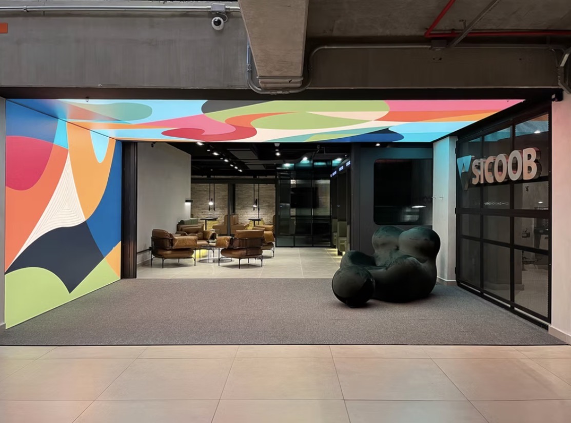 Intervenção artística colorida em parede e teto de ambiente corporativo